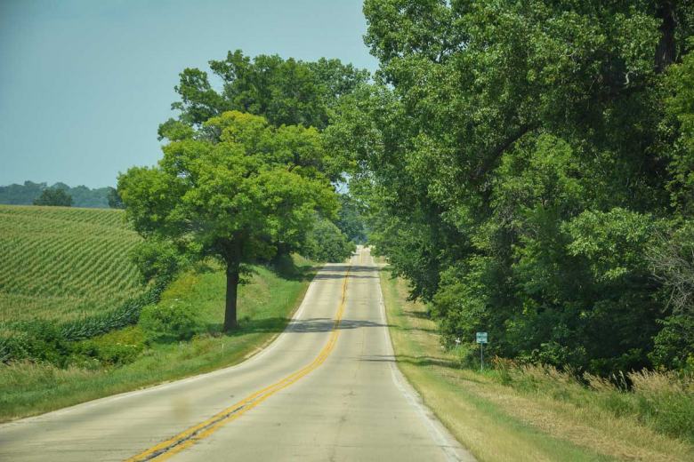 Die hügelige Landschaft von Illinois entlang der Great River Road – Sojabohnen und Mais, Farmen mit roten Scheunen und Dörfer mit schattigen Holzhäusern wechselten einander ab.