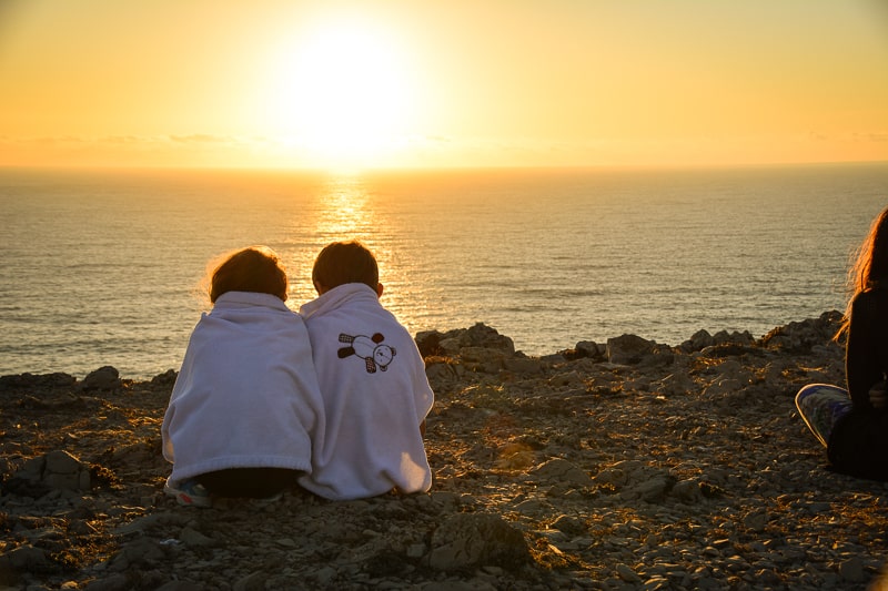 Die Kinder genießen den Sonnenuntergang in Sagres